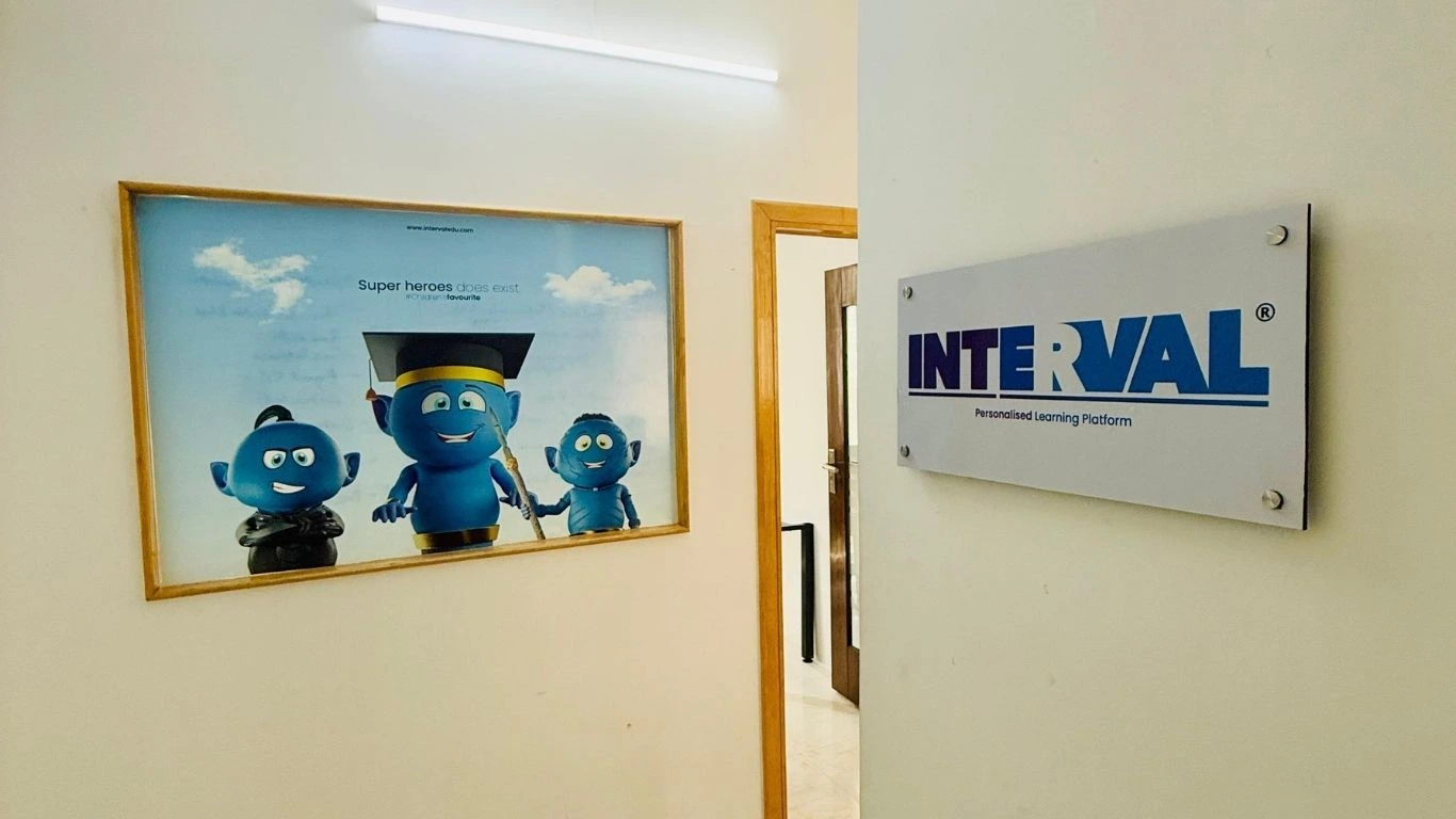 Interval Learning office entrance showcases brand signage and a kid-friendly genie-themed education poster.
